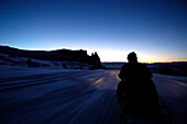 Mann auf Motorschlitten im Abendlicht, Schneemobil, Skidoo, Seiser Alm, Schlerngebiet, Südtirol, Italien