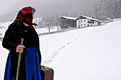 Bäuerin geht durch den Schnee, Abschied, Bauernhof, Landwirtschaft, Südtirol, Italien