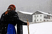 Bäuerin geht durch den Schnee, Bauernhof, Landwirtschaft, Südtirol, Italien