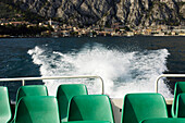 Blick über die Stühle eines Ausflugsboots auf die Stadt Limone, Gardasee, Italien, Europa