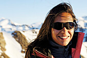 Lächelnde Frau mit Sonnenbrille vor verschneiten Bergen, Schnalstal, Vinschgau, Südtirol, Italien, Europa