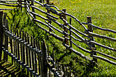 Wooden fence on a meadow in the sunlight, South Tyrol, Italy, Europe