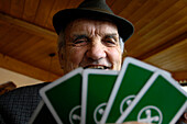 Das Gesicht eines alten Mannes über Spielkarten, Südtirol, Italien, Europa
