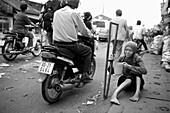 Una mujer invalida pide limosna en la calle, My Tho, Vietnam