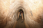 Un hombre en el interior de un tunel Cu Chi, Vietnam