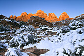 Sandstone ridge glows at sunset beneath a blue winter sky near Ken's Lake south of Moab, Utah, USA