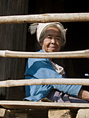 Old Pa O woman sitting on her balcony at Inle Lake in Myanmar