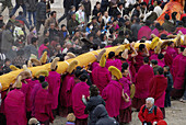 monks are carry a long huge thanka up a mountain in Labrang, Gansu, China