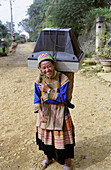 A flower Hmong woman on her way to the weekly market....with her TV set!!