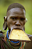 Portrait of a Surma woman wearing a wooden disc plate in her lower lip, Ethiopia