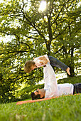 Father and daughter (2-3 years) playing on grass, English Garden, Munich, Bavaria, Germany