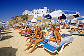 Telephoning girl, people on the beach under blue sky, Albufeira, Algarve, Portugal, Europe