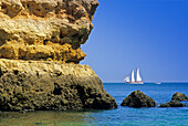 Segelschiff vor der Felsküste unter blauem Himmel, Praia do Camilo, Algarve, Portugal, Europa