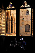 Museo Nazionale del Bargello, window to the courtyard and two tourists sitting in the shadow, Florence, Tuscany, Italy, Europe