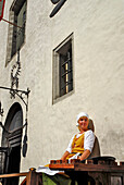 Waitress in front of Olde Hansa Restaurant, which serves medievel dishes, Tallinn, Estonia