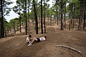 Hiker, resting under pine trees, El Julan, El Hierro, Canary Islands, Spain
