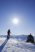 Female backcountry skier beside cairn, Hirzer, Tux Alps, Tyrol, Austria