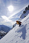 Woman downhill skiing through powder snow, Mangfall range, Upper Bavaria, Bavaria, Germany