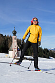 Cross-country skier, chapel in background, Dolomite Alps, Trentino-Alto Adige/Südtirol, Italy