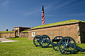 USA, MD, Baltimore. Cannons set outside the entrance to the historic Frot McHenry, where the Star Spangled Banner was written. Seen here with the historic 15 star flag.