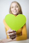 Businesswoman holding cut-out heart