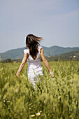 Woman in white dress walking in the countryside