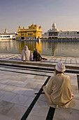 People praying at sunset in front of the Sikh Golden Temple of Amritsar, Punjab, India