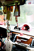 Buddhist prayer and fortune chains made of jade hanging at the rear view mirror of a taxi, Taiwan, Asia