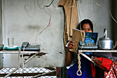 Lesende Frau sitzt hinter Telefonen, Möglichkeit zu telefonieren, Rangoon, Myanmar, Birma, Asien