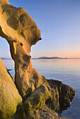 Evening light on sandstone formations of Larrabee State Park, Washington, USA. In the distance are the San Juan Islands.