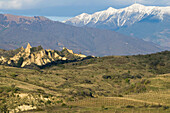 Mountains in South Bulgaria, hoodoo rocks of Melnik and snow-covered peak of Pirin mountains, cultivated landscape with vineyards, Bulgaria