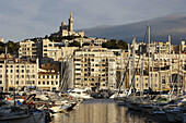 French. Provence. Marseille. Yachts dock in the Old Port (Port Vieux) of Marseille with Basilica of Notra Dame de la Garde in the background.