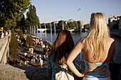 France. Paris. Two girls look at the walk way of River bank of Seine during Paris Plage.