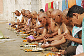 By the Ganges river people who dedicated thier hair to God having lunch, Varanasi, India