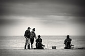 Tertulia de pescadores de caña junto al mar.