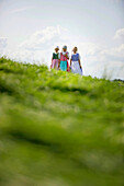 Drei Mädchen in Dirndl auf einer Wiese, Münsing, Bayern, Deutschland