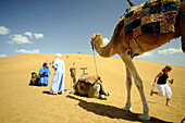 Einheimische, Touristen und Kamele auf einer Düne, Draa-Tal, Süd Marokko, Marokko, Afrika