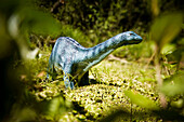 Toy apatosaurus in a geen scenery