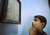 5240  INDIA - RELIGION - CHRISTIAN  SYRIAN-CATHOLIC BOY AT HOME PRAYING  TRICHUR, KERALA