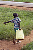 UGANDA  Boy carrying jerry can, Village of Kabembe, Mukono District