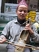 Nepali musician playing traditional instrument