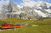 Jungfraubahn train with the Eiger and Monch mountains and the Eigergletscher glacier, Bernese Oberland, Switzerland