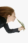 Beautifull woman smelling Rosemary