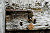 Wooden door with iron bar and rusty padlock, Pila, Centovalli, lake Maggiore, Lago Maggiore, Ticino, Switzerland