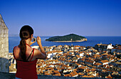 Young woman taking a picture of the Old Town of Dubrovnik, Croatian Adriatic Sea, Dalmatia, Croatia, Europe