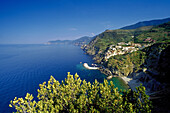 Blick auf Küstenlandschaft und Riomaggiore unter blauem Himmel, Cinque Terre, Ligurien, Italienische Riviera, Italien, Europa