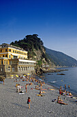 Menschen und Hotel am Strand unter blauem Himmel, Camogli, Italienische Riviera, Ligurien, Italien, Europa