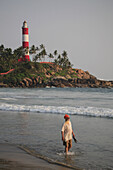 Man walking on Lighthouse beach, Kerala, India