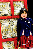 A Mongolian girl stands near the door of her familys Ger / Yurt  traditional home