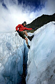 Mountain guide abseiling in glacier crevasse